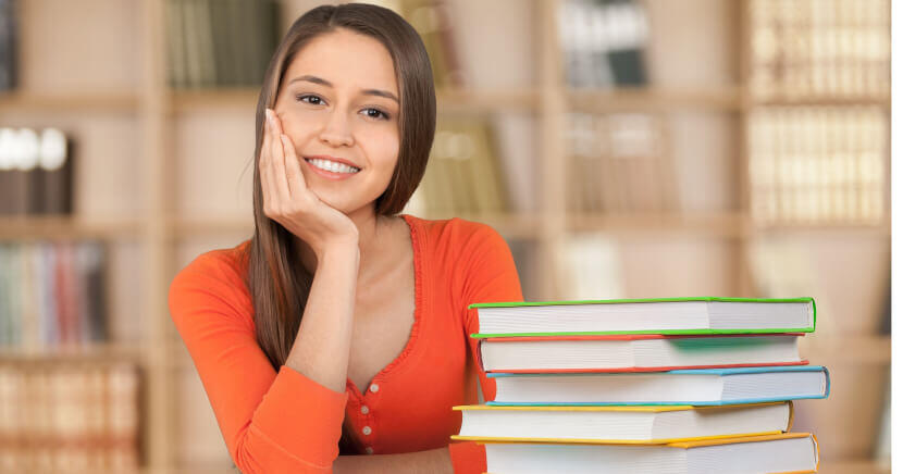 Female-Sitting-At-Desk-In-Library