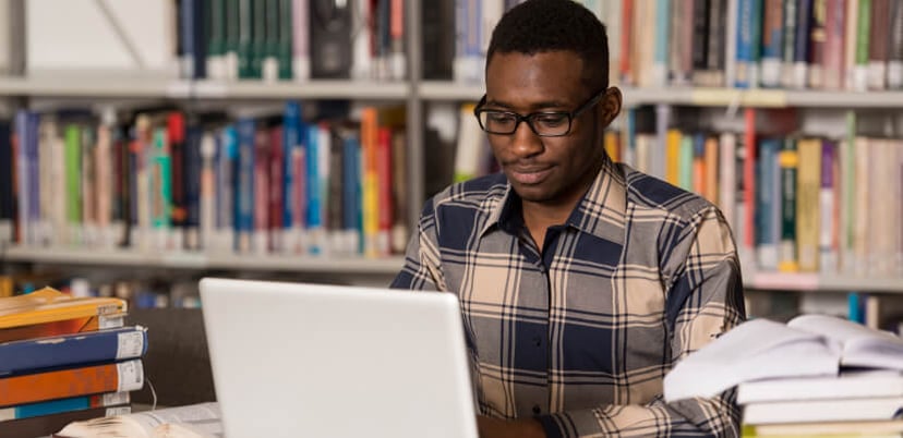 Smiling-student-looking-at-laptop