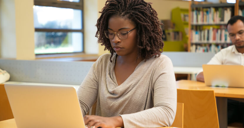 Two-people-working-on-laptops-in-library