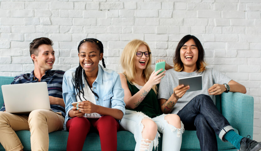 friends-on-couch-using-different-devices