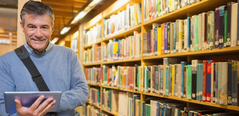 man-holding-tablet-in-library