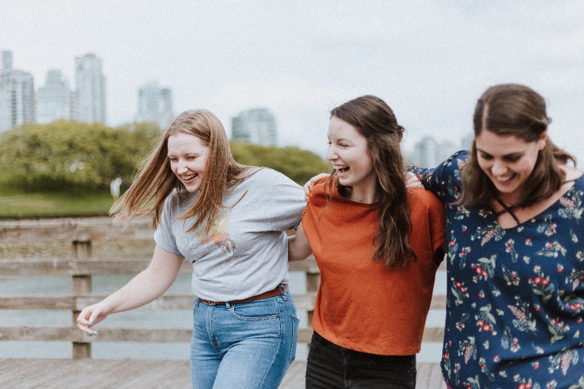 Three women laughing outside