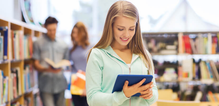 student-in-library-holding-tablet