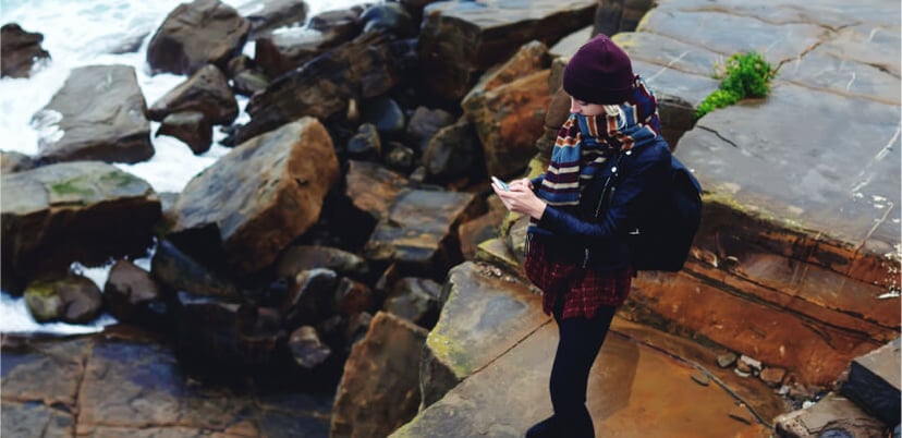 woman-outdoors-reading-on-smartphone